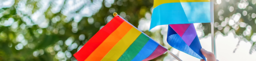 Hand holding rainbow and pansexual pride flags outdoors, representing LGBTQ+ community support and health awareness.