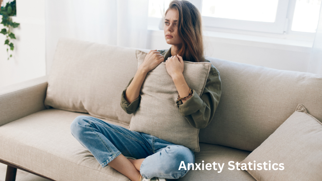 Woman sitting on a couch holding a pillow, appearing anxious and distressed in a home setting